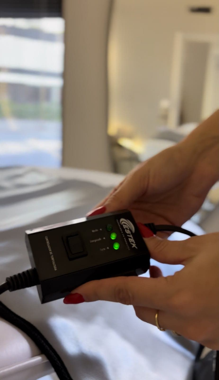 Mãos ajustando o controle de temperatura da manta térmica