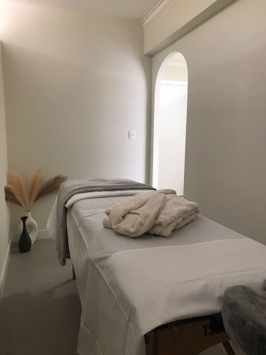 Primeira sala de atendimento, com maca e arco na parede