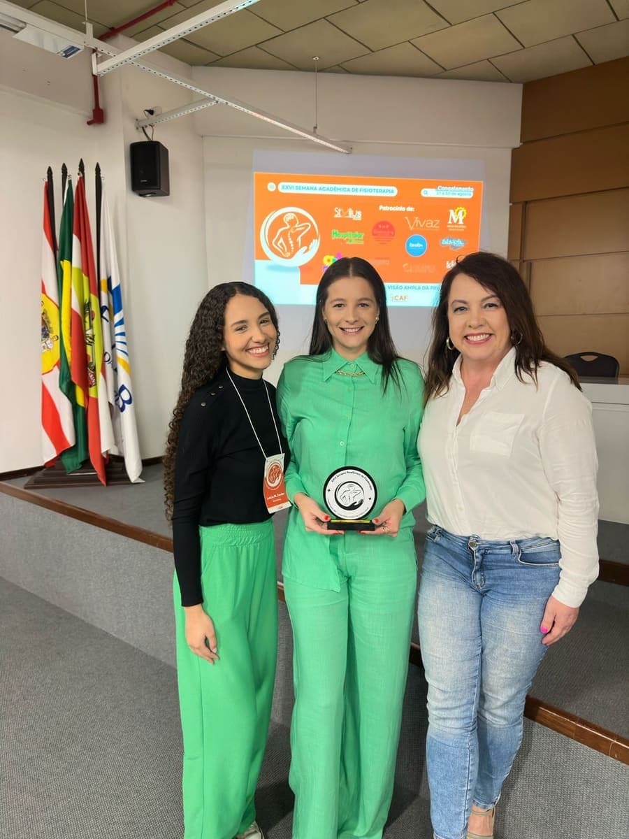 Carol recebendo homenagem como palestrante na FURB